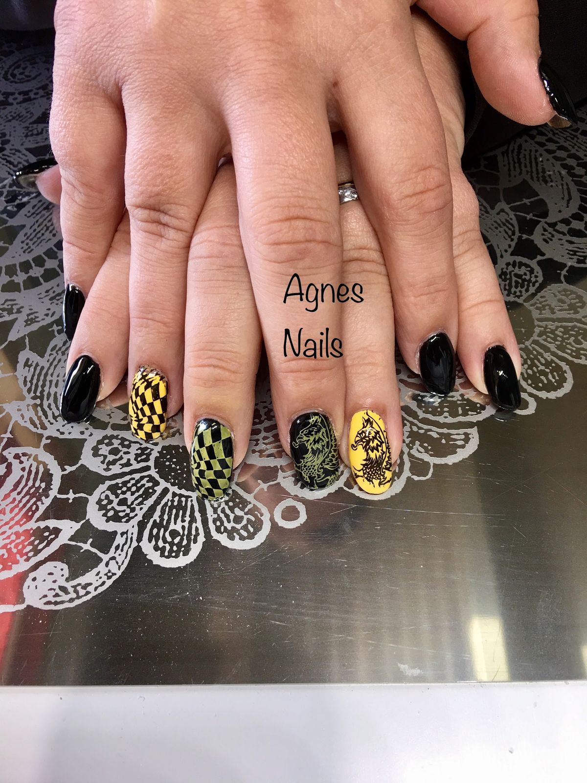 Zwarte nagels met geel-groen ruitpatroon en gestempelde bloemen