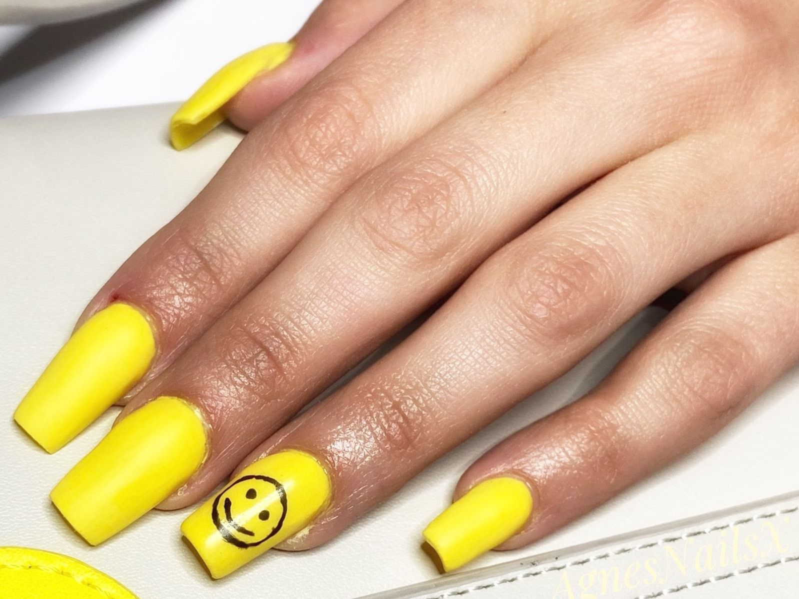 Matgele coffin-nagels met een smiley als accentnagel